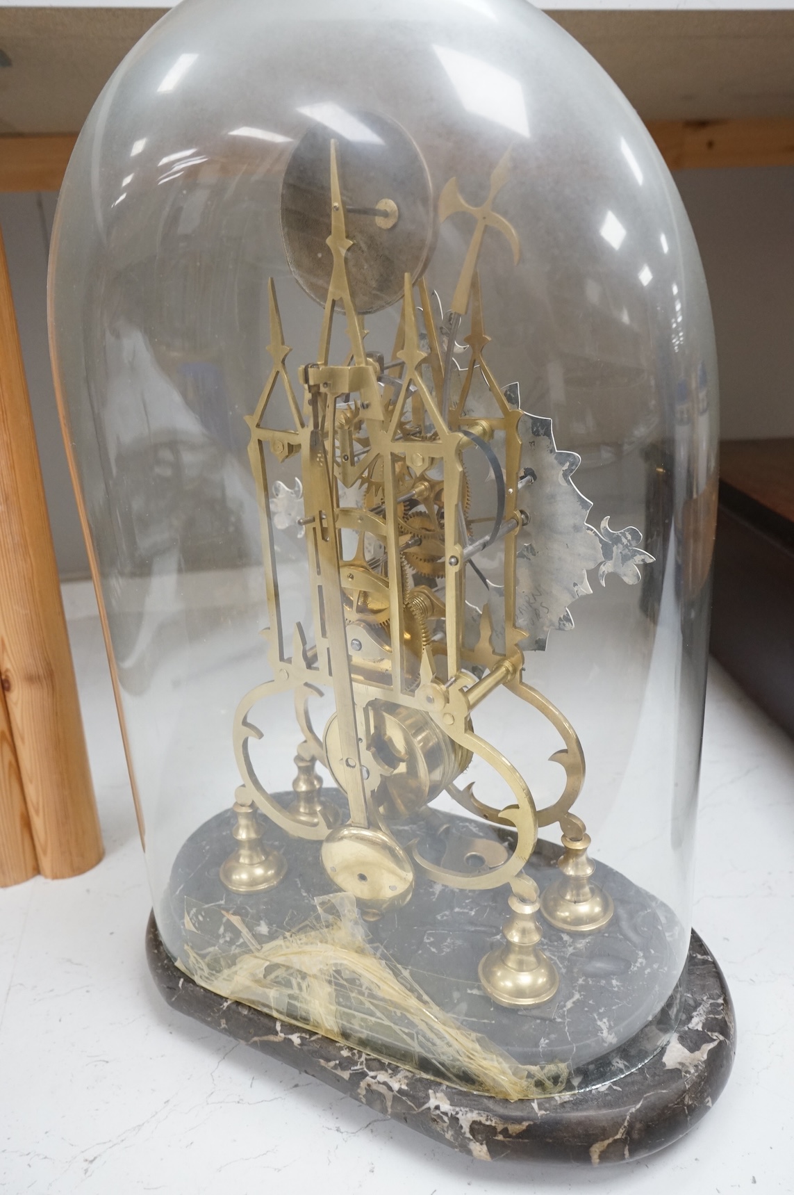 A large skeleton clock under dome, on grey marble base. 44cm high